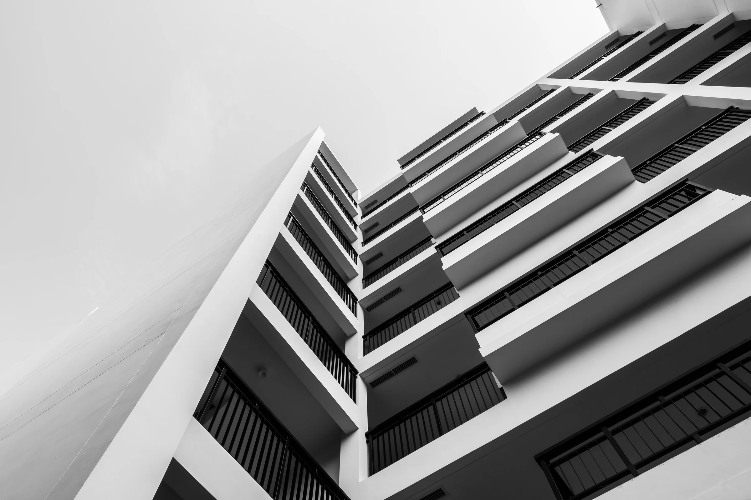 Black and white architectural view looking up at a modern building