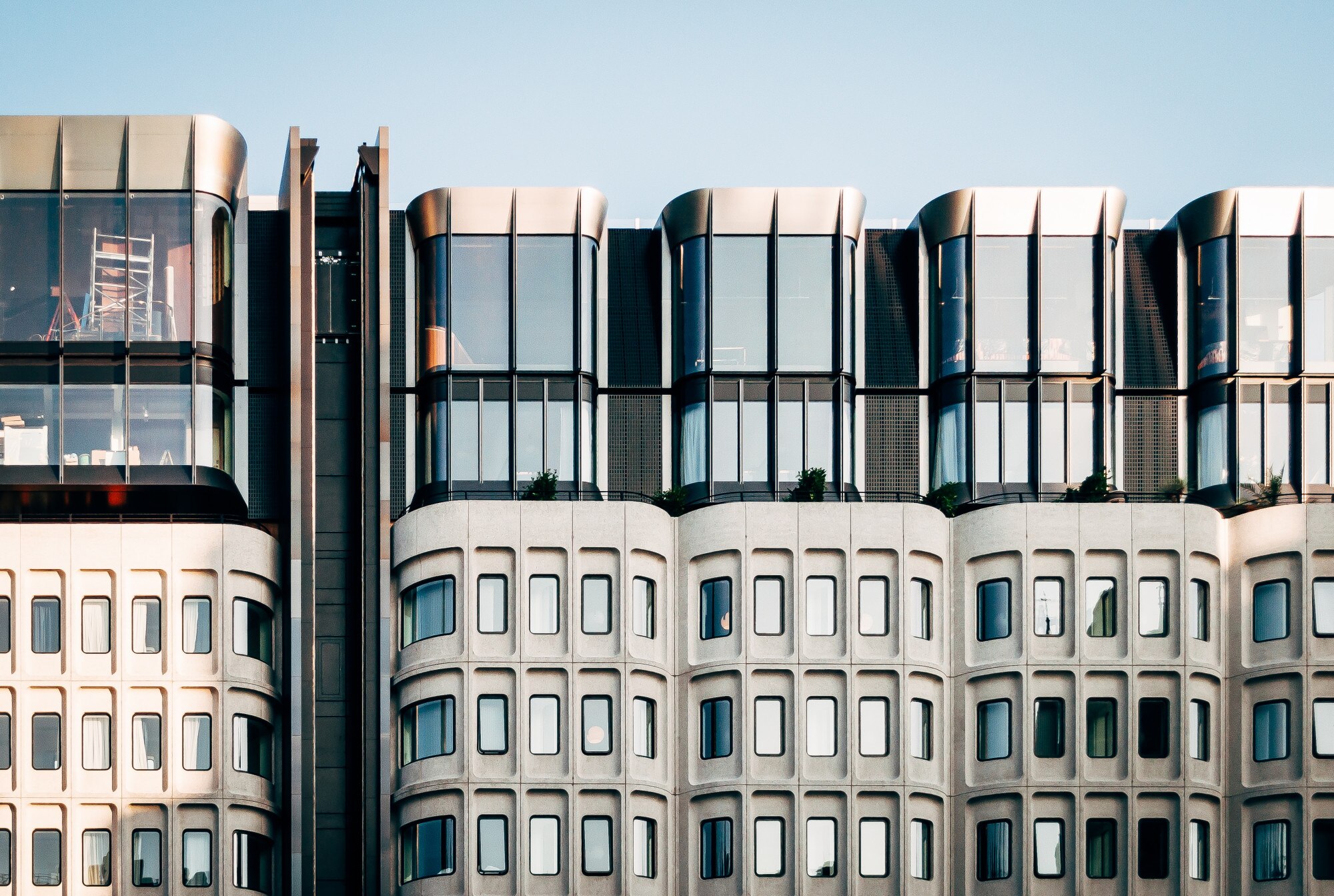 Modern commercial building with rhythmic glass storefronts and pale stone facade
